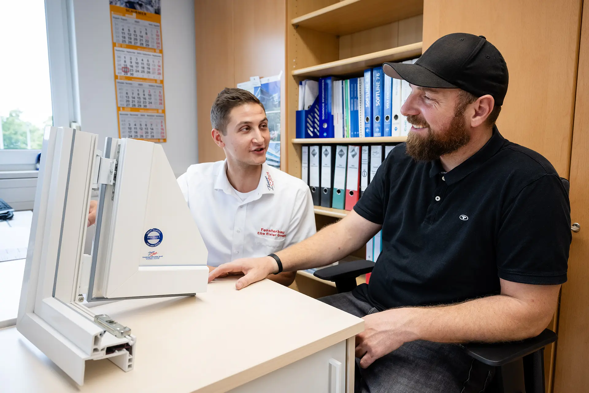 JS10b Zwei Mitarbeiter schauen sich einen Fensterrahmen an