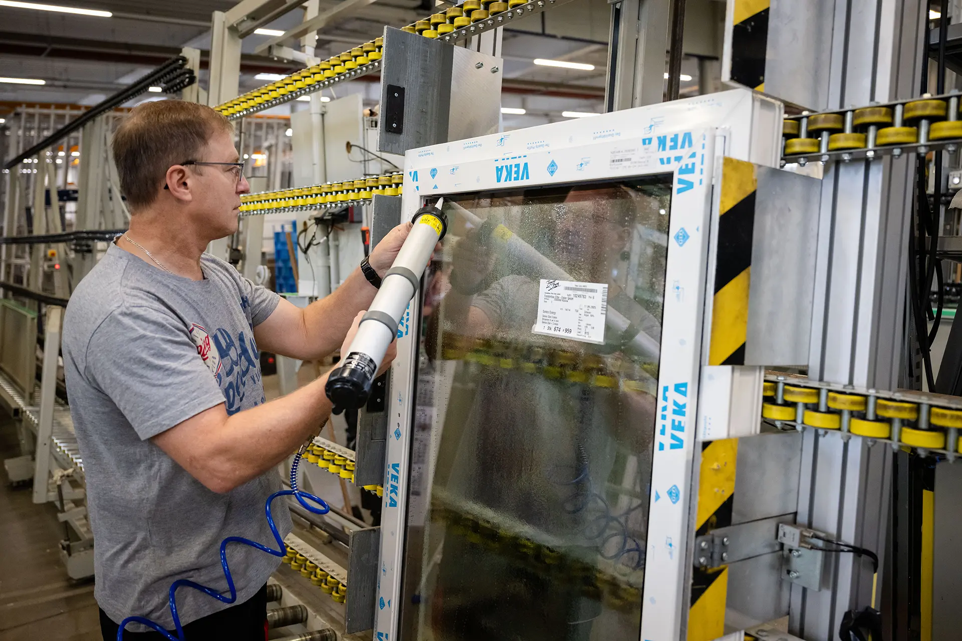 Mitarbeiter dichtet Fenster ab