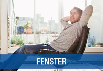 Mann sitzt bequem vor einer Fensterfront